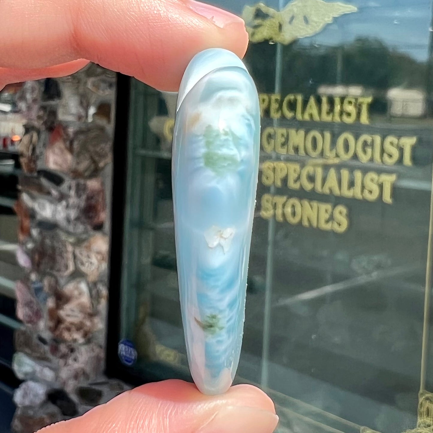 A loose, carved, heart shaped larimar stone. Predominant colors are blue and white.