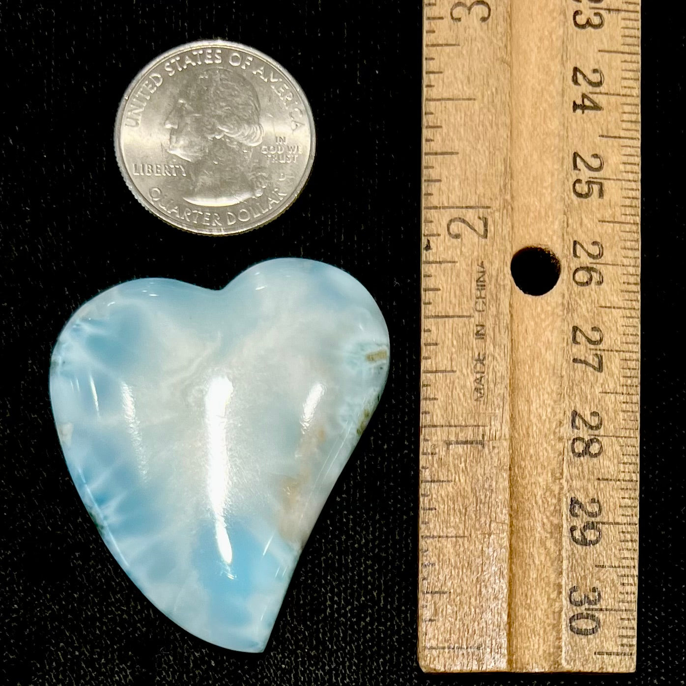 A loose, carved, heart shaped larimar stone. Predominant colors are blue and white.