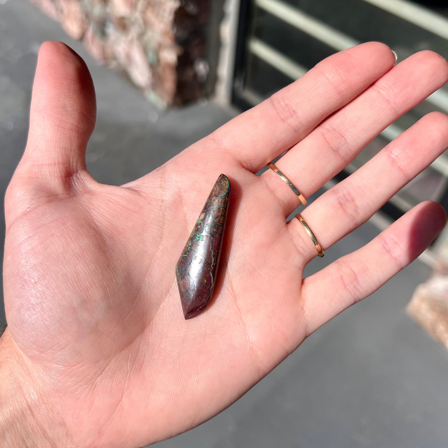 A loose, freeform cabochon cut Koroit boulder opal stone.