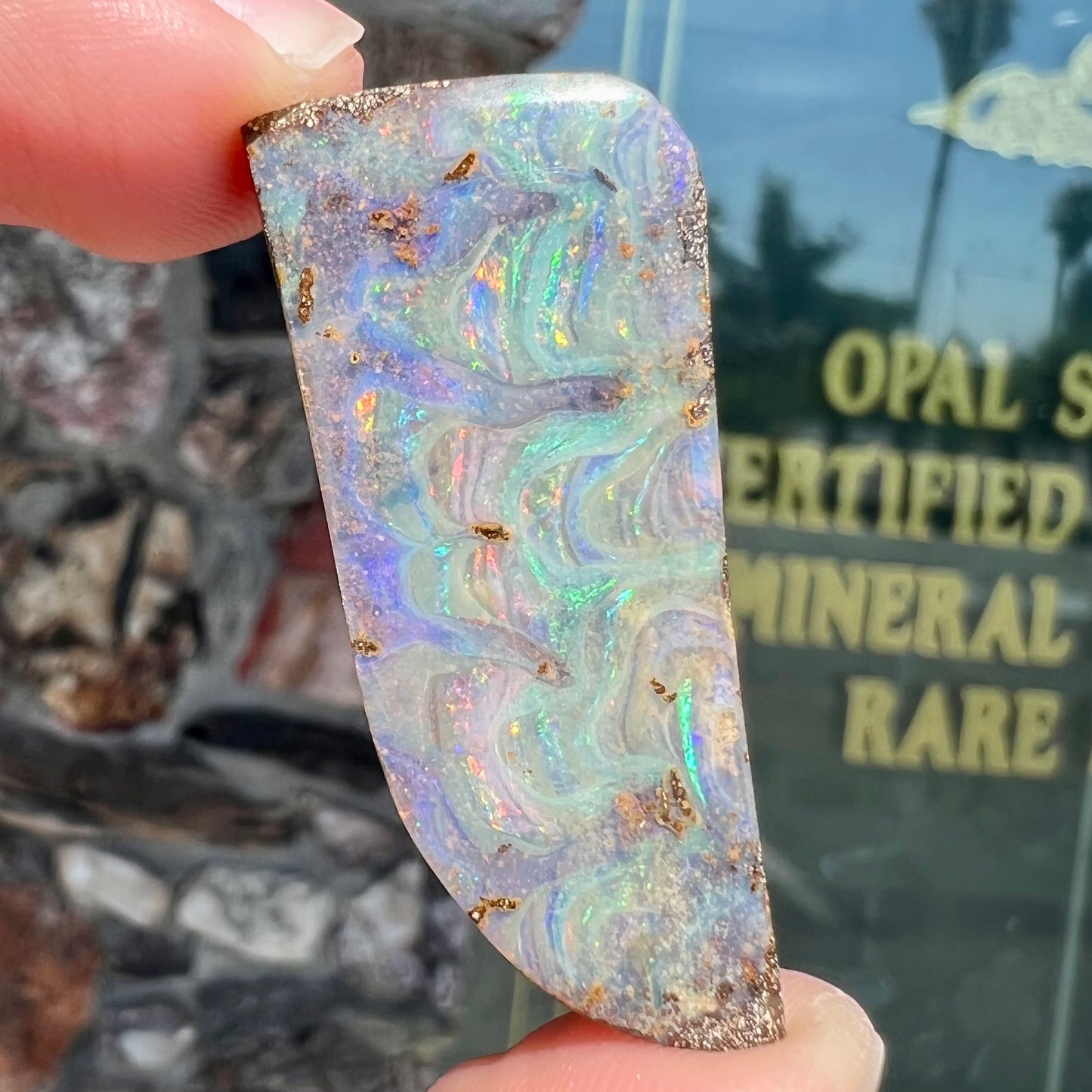 A loose, freeform cut, natural boulder opal stone from Quilpie, Australia.