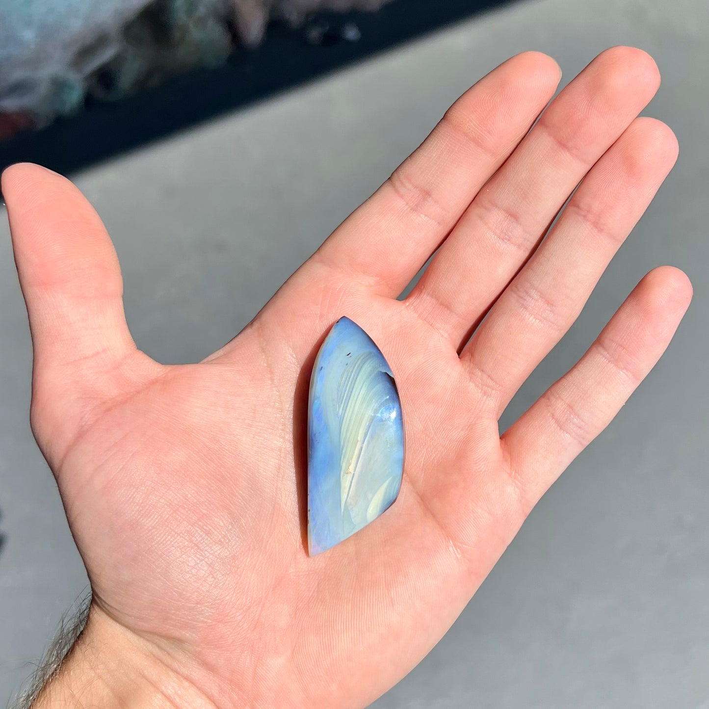 A loose, polished blue boulder opal stone from Queensland, Australia.