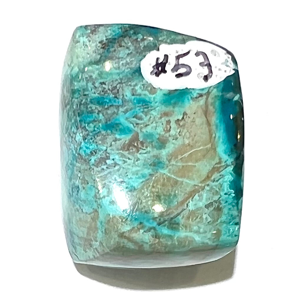 A loose, polished turquoise specimen with azurite inclusions.