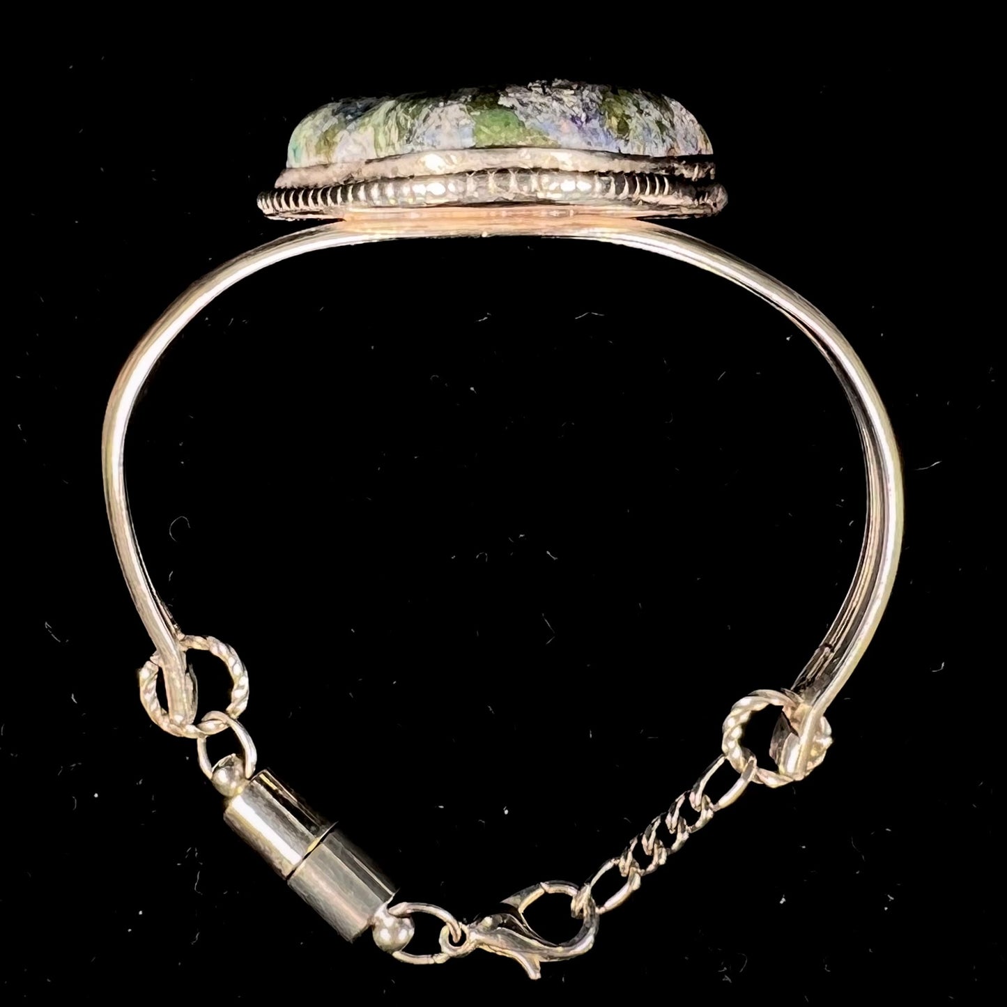 A handmade sterling silver cuff bracelet set with a single stone formed from variscite, chrysocolla, and azurite.