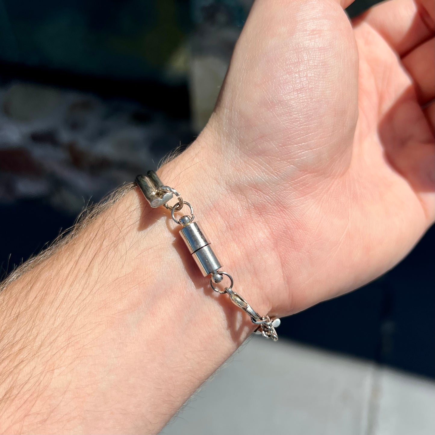A handmade sterling silver cuff bracelet set with a single stone formed from variscite, chrysocolla, and azurite.
