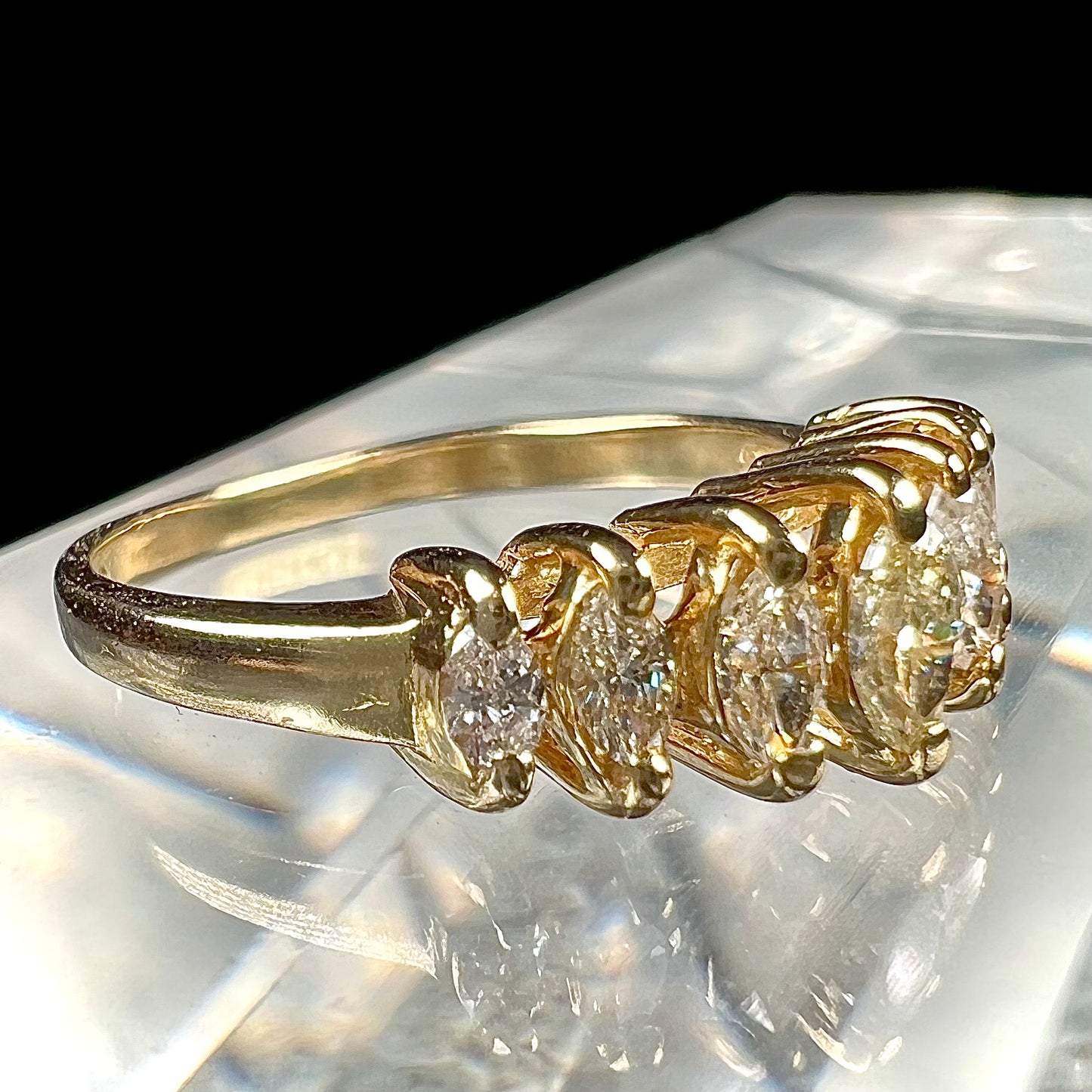 An estate yellow gold ring prong set with seven marquise cut diamonds.