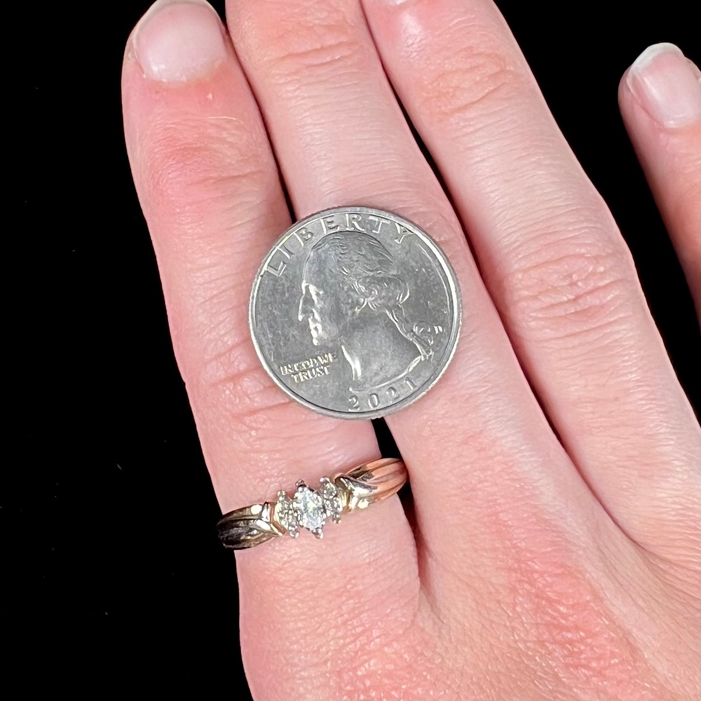 A ladies' two-tone white and yellow gold marquise cut diamond enagagement ring. There are round diamond accents.