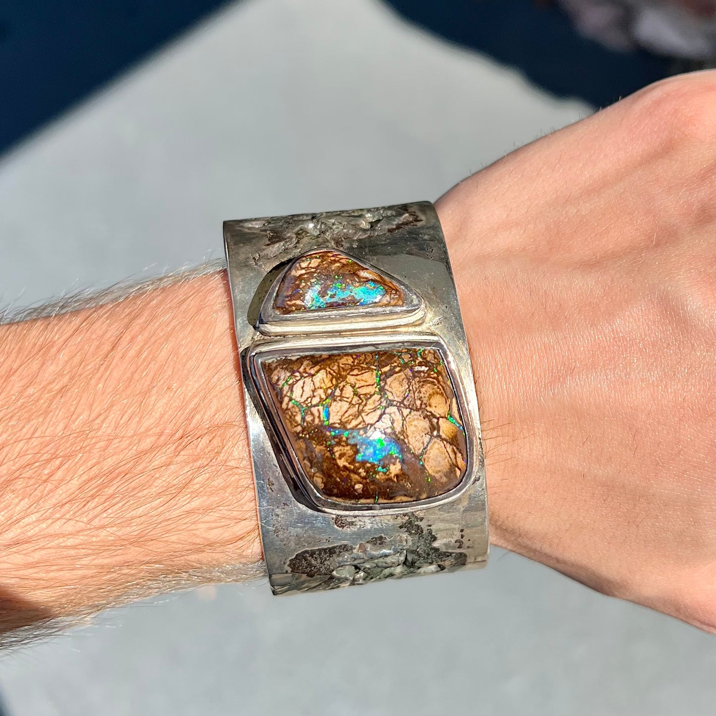A men's sterling silver and copper infused cuff bracelet set with two boulder opal stones from Koroit, Australia.
