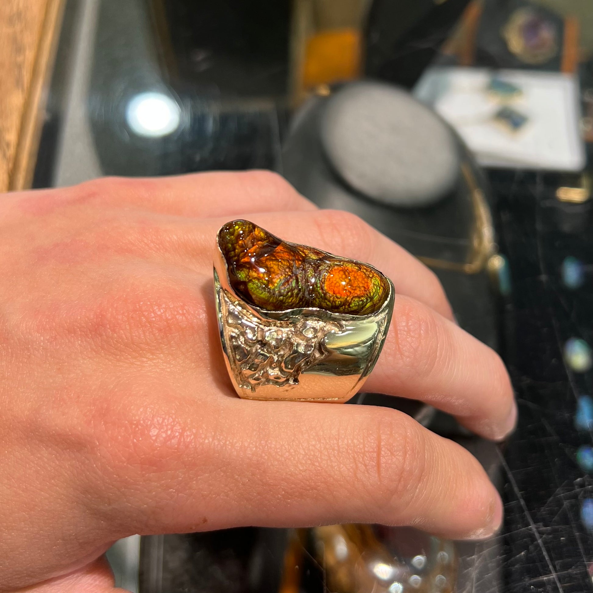 A large nugget style men's fire agate ring cast in yellow gold.  The fire agate is predominantly orange and green.