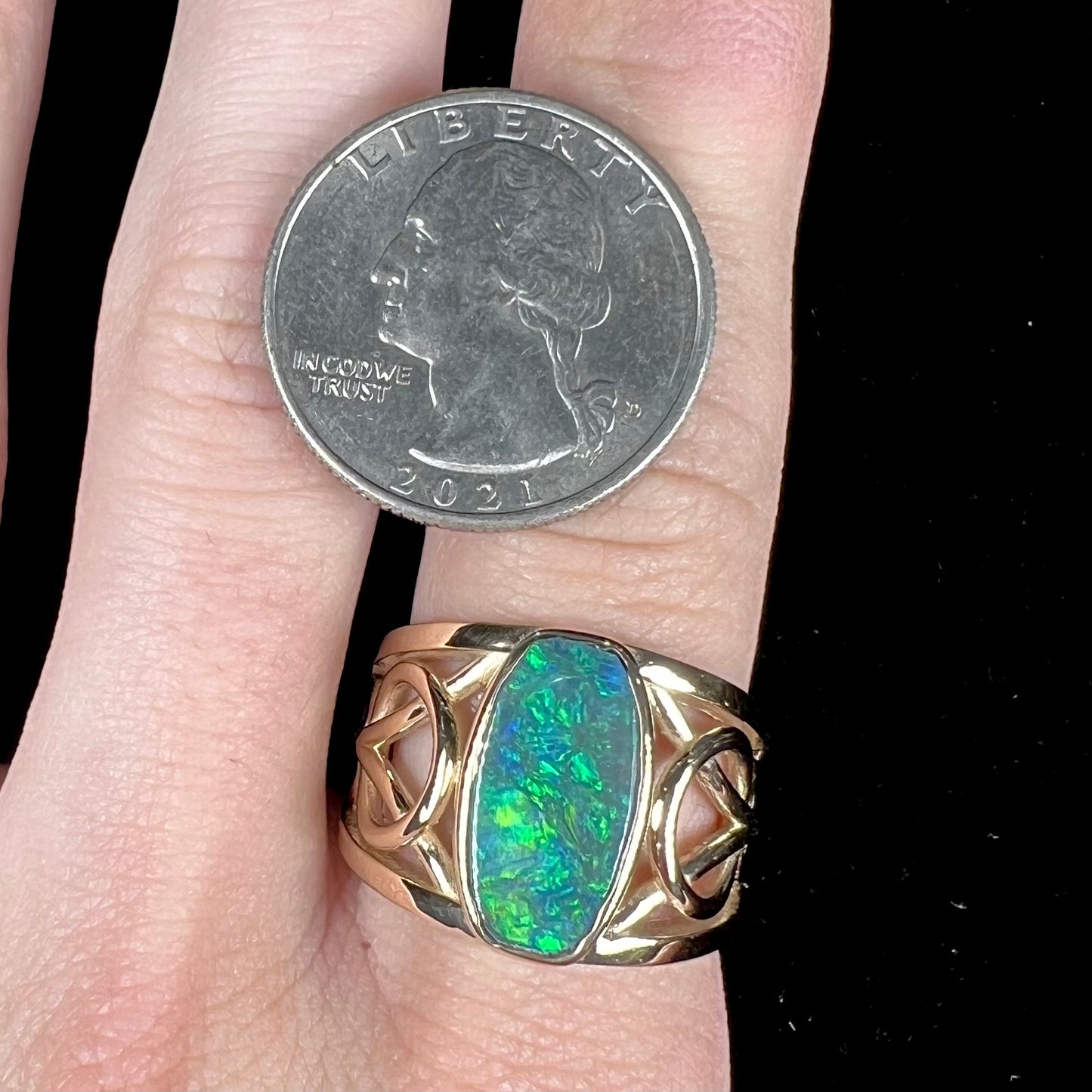 A men's natural Lightning Ridge, Australian black opal solitaire ring cast in yellow gold.