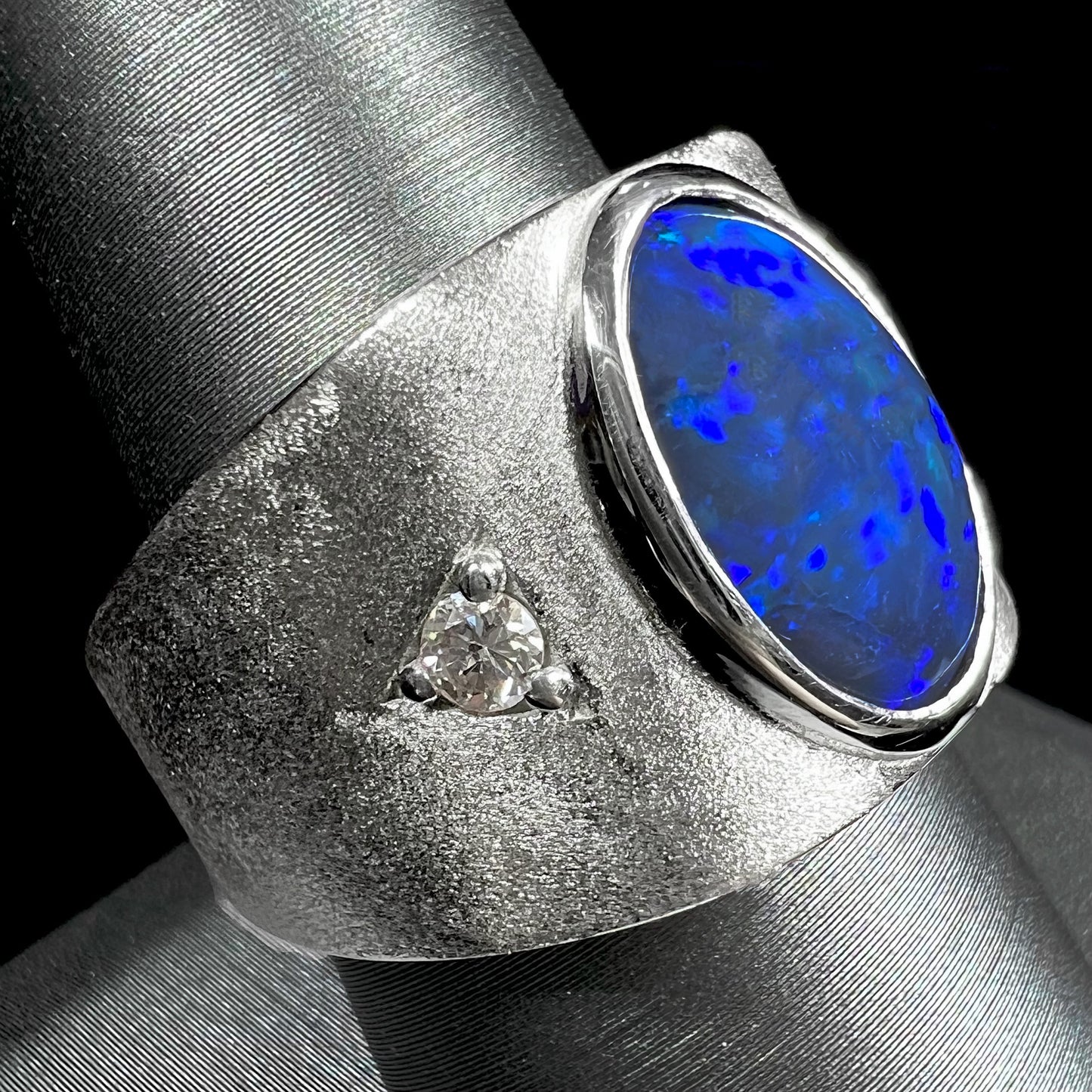 A men's natural black opal and diamond ring cast with a matte finish in white gold.