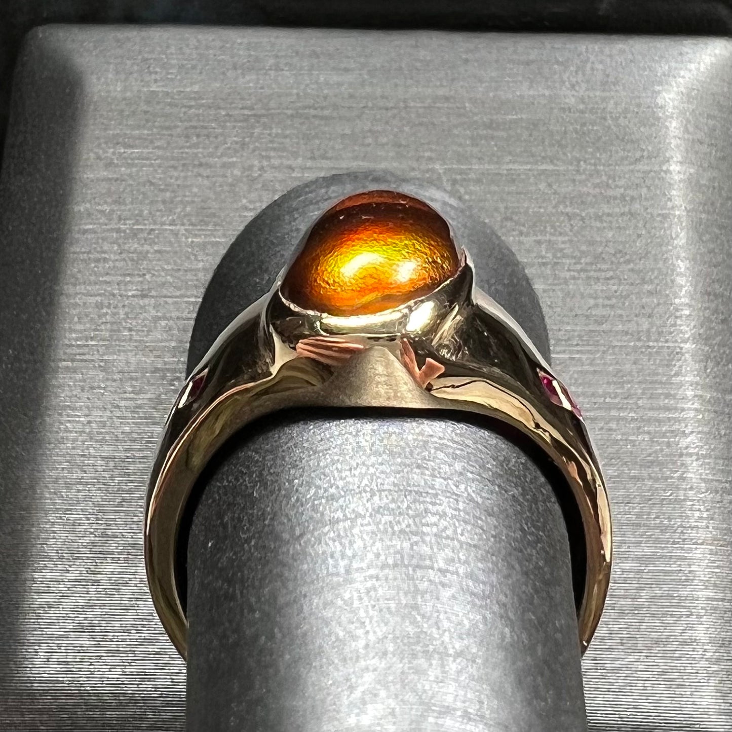 A yellow gold men's ring set with princess cut Burma rubies and a freeform cabochon cut red fire agate from Slaughter Mountain, Arizona.