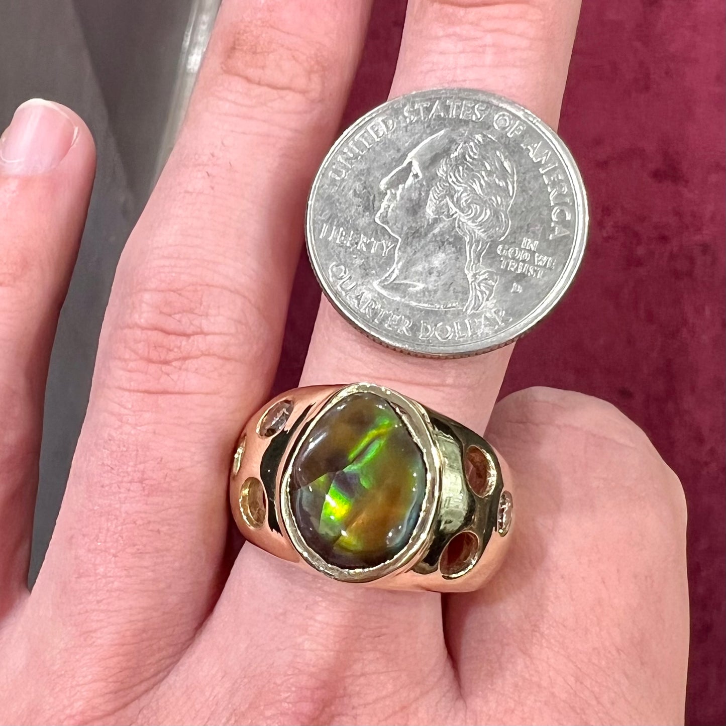 Men's rainbow fire agate ring set in yellow gold with champagne diamonds. The ring style has holes.