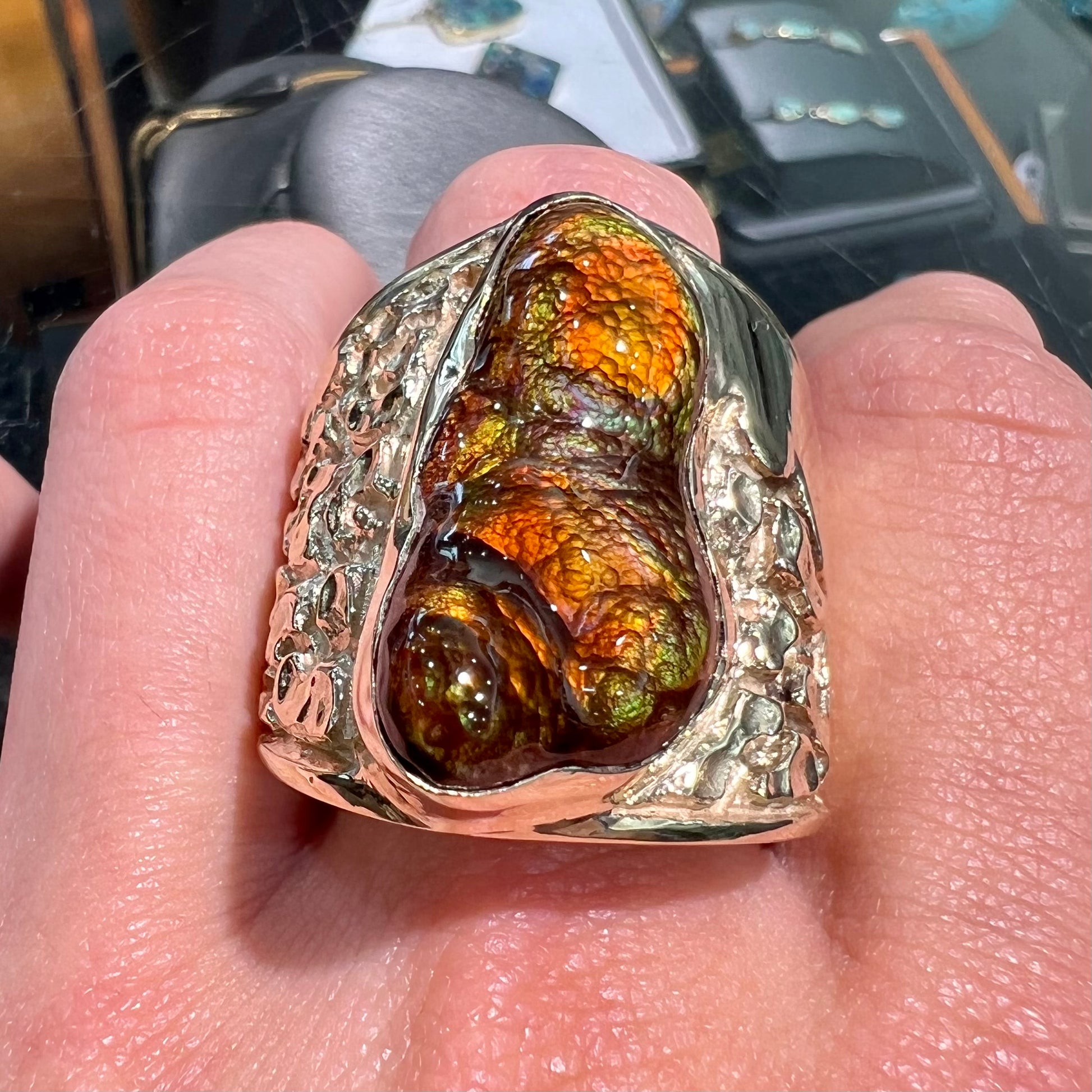 A large nugget style men's fire agate ring cast in yellow gold.  The fire agate is predominantly orange and green.