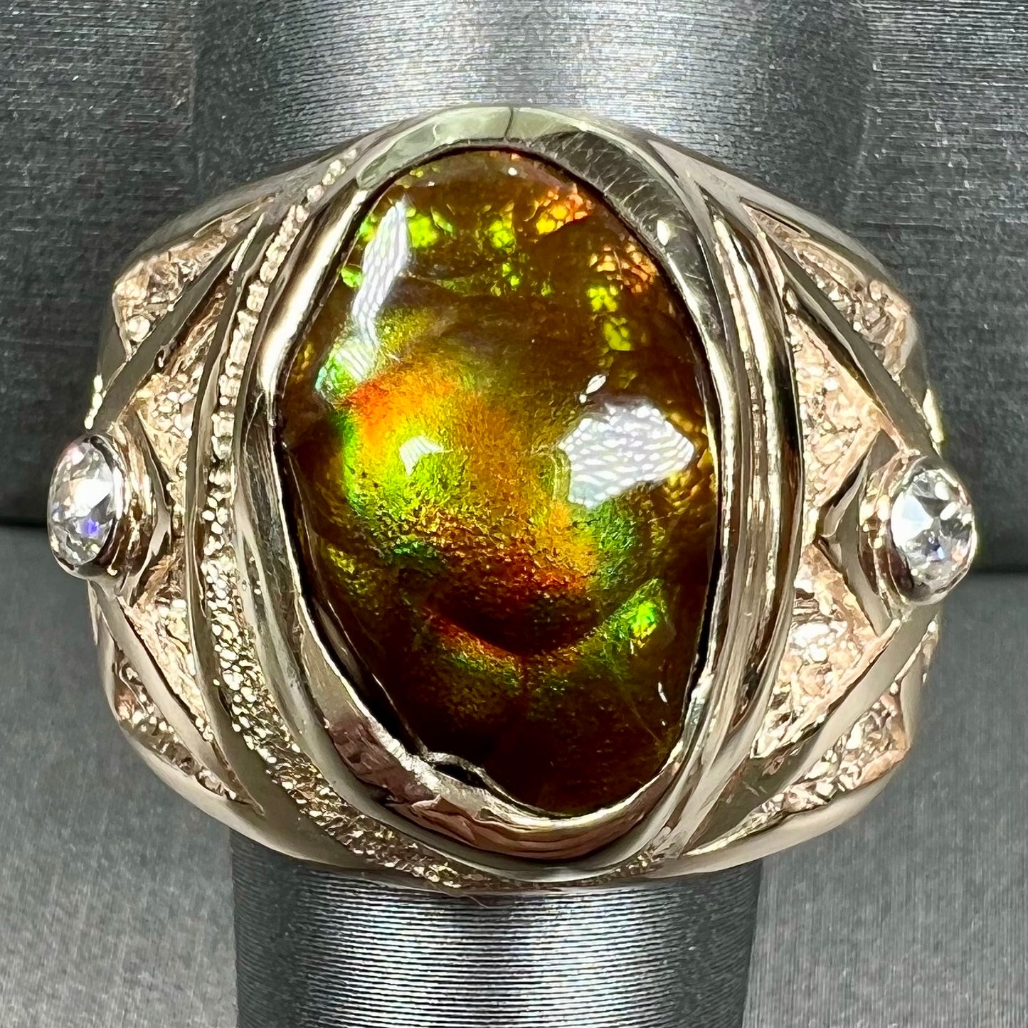 A men's solid yellow gold fire agate and diamond ring. The fire agate displays predominantly red and green.