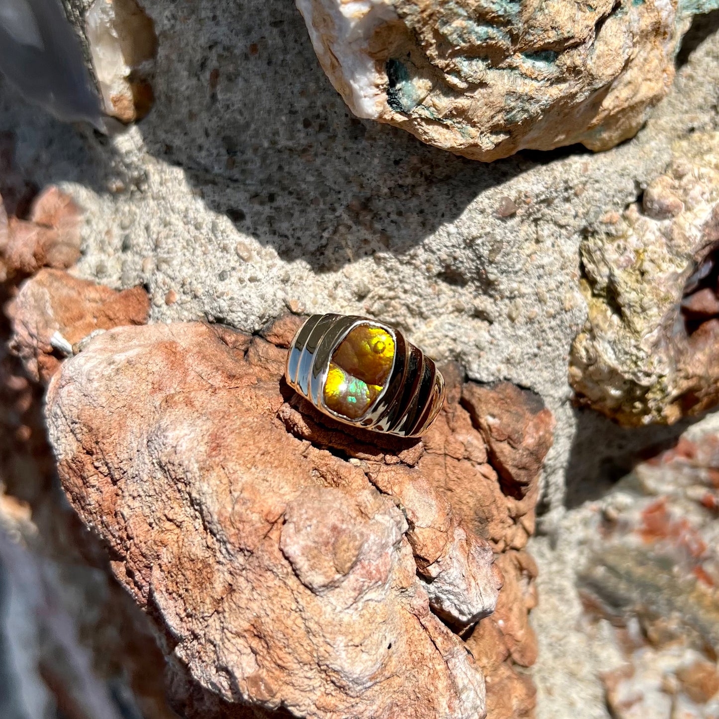 Men's fire agate solitaire ring cast in yellow gold. The ring is a step design.