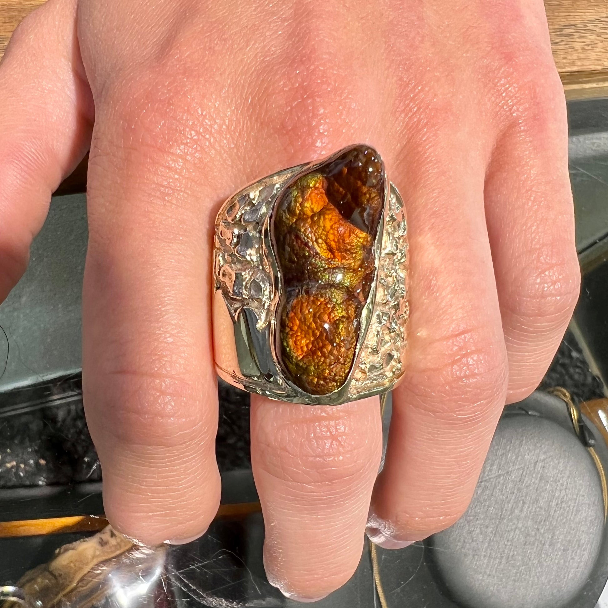 A large nugget style men's fire agate ring cast in yellow gold.  The fire agate is predominantly orange and green.