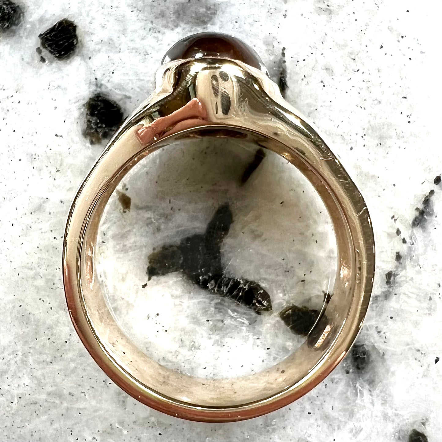 A yellow gold men's ring set with princess cut Burma rubies and a freeform cabochon cut red fire agate from Slaughter Mountain, Arizona.