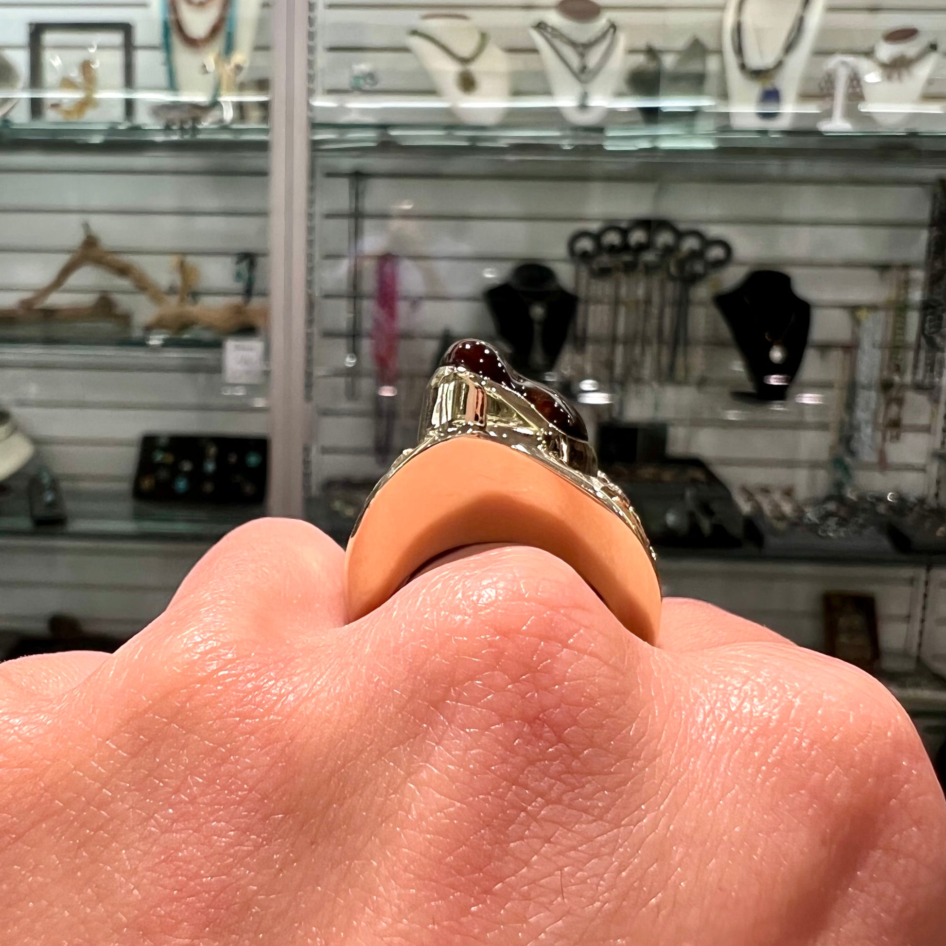 A large nugget style men's fire agate ring cast in yellow gold.  The fire agate is predominantly orange and green.