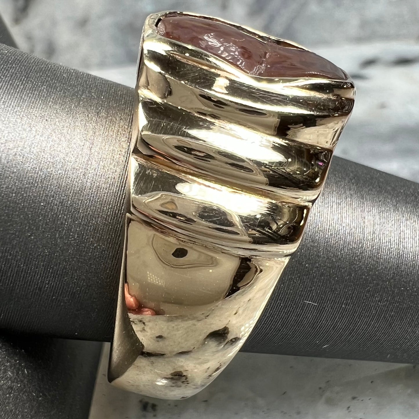 Men's fire agate solitaire ring cast in yellow gold. The ring is a step design.
