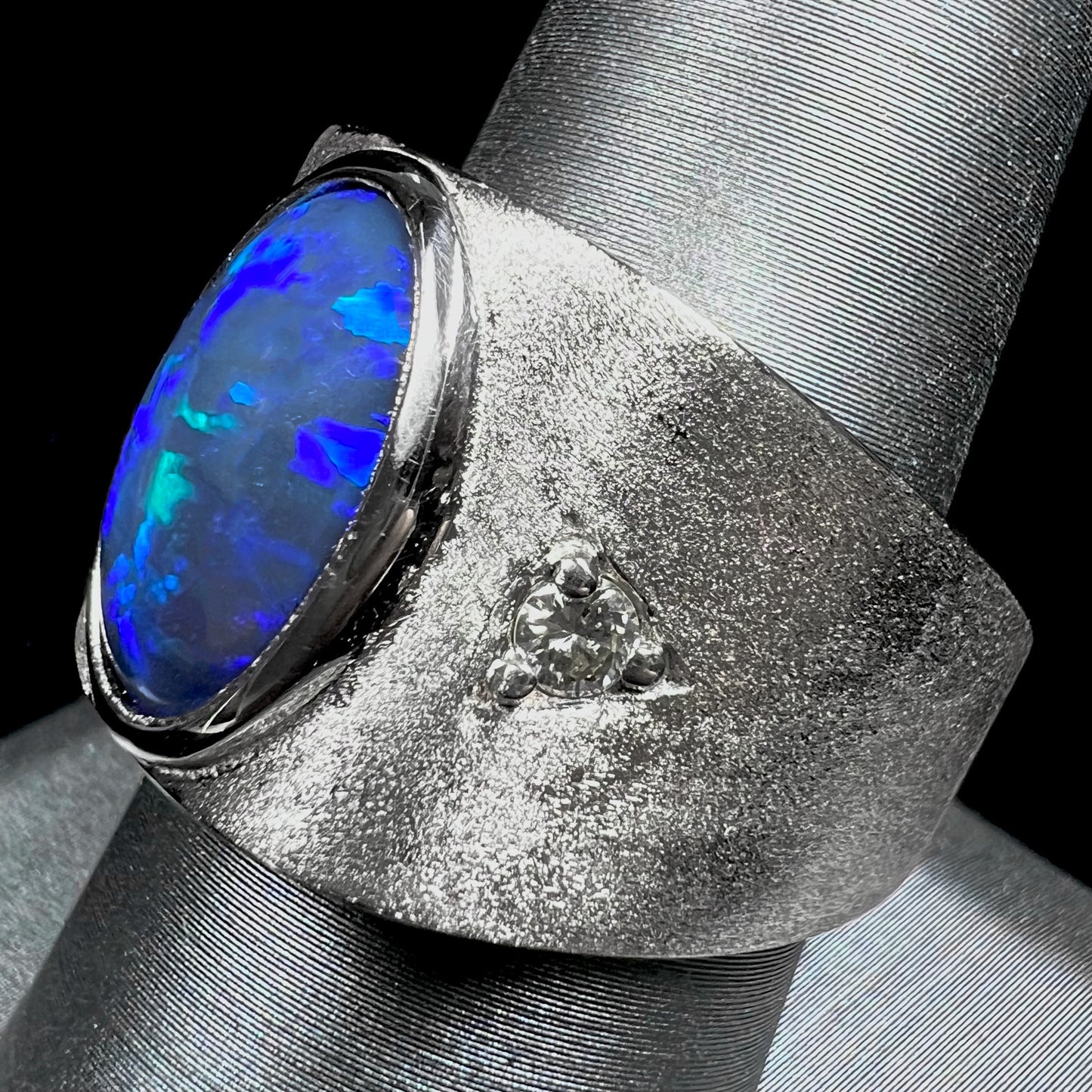 A men's natural black opal and diamond ring cast with a matte finish in white gold.