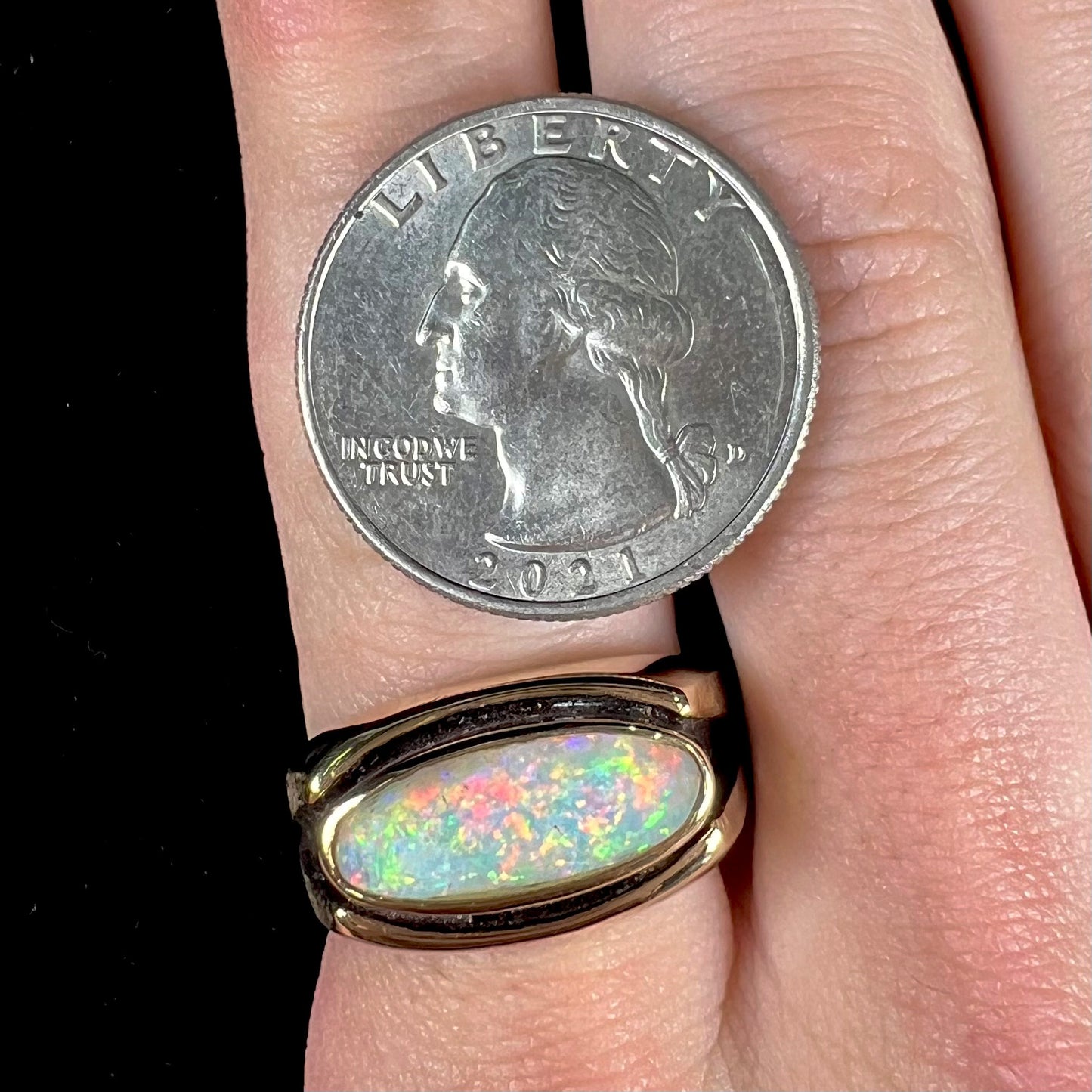 An Australian white crystal opal men's ring in solid yellow gold. The recesses of the ring have been blackened.