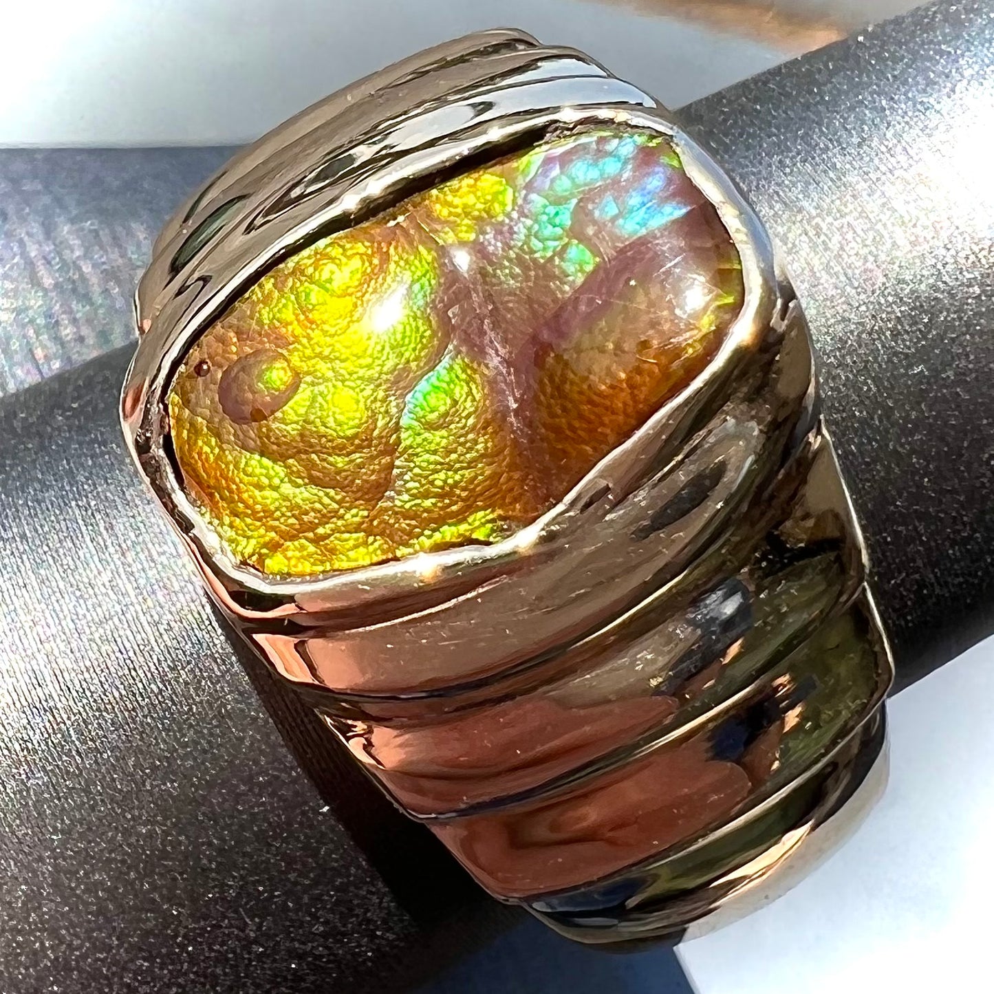 Men's fire agate solitaire ring cast in yellow gold. The ring is a step design.