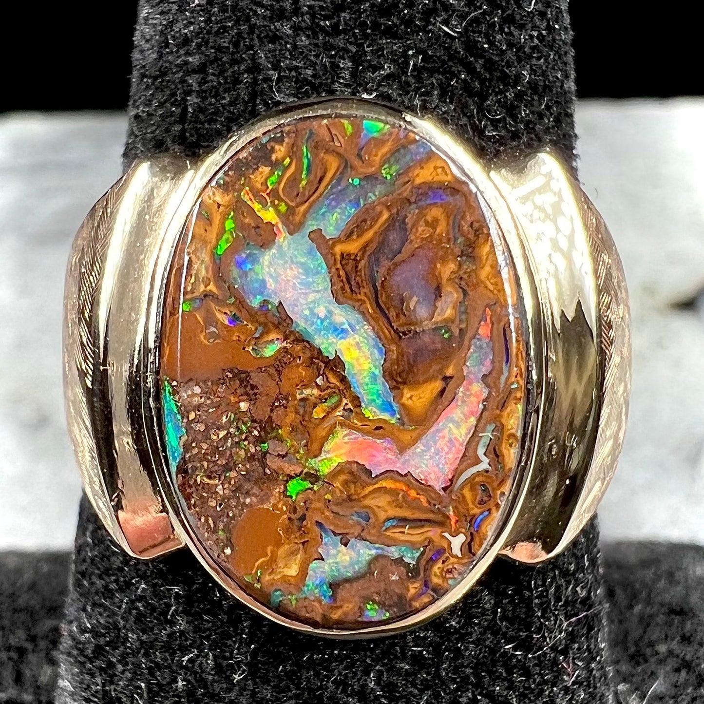 A Koroit boulder opal men's ring in brushed yellow gold.
