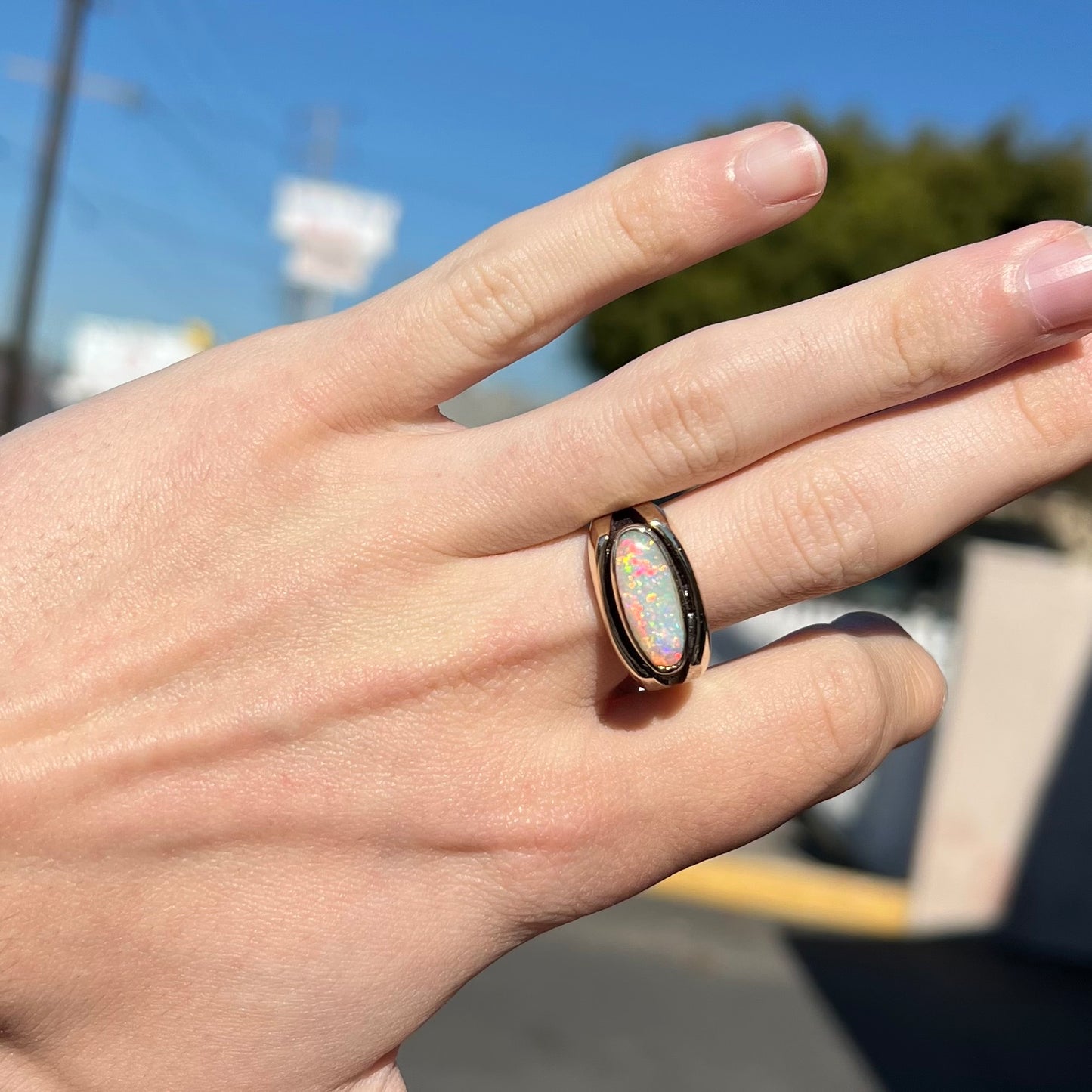 An Australian white crystal opal men's ring in solid yellow gold. The recesses of the ring have been blackened.