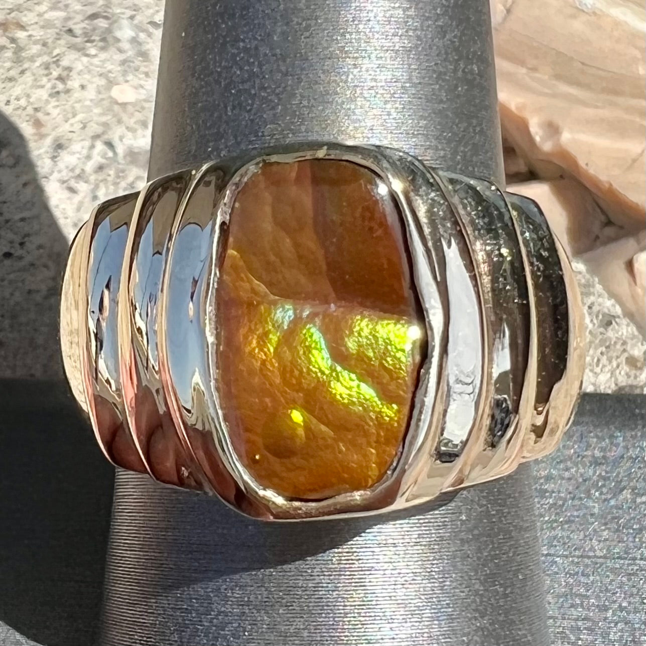 Men's fire agate solitaire ring cast in yellow gold. The ring is a step design.