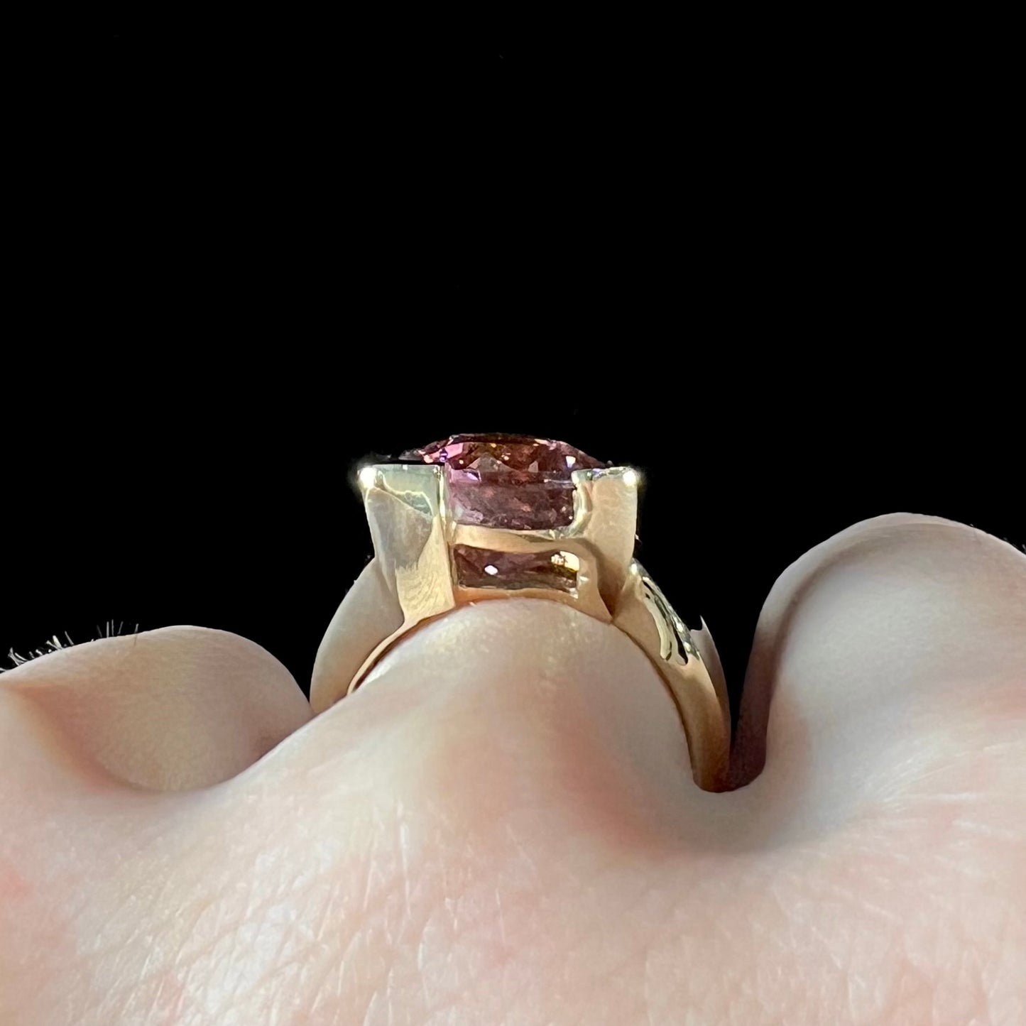 A unisex, yellow gold, trillion cut pink tourmaline solitaire ring.