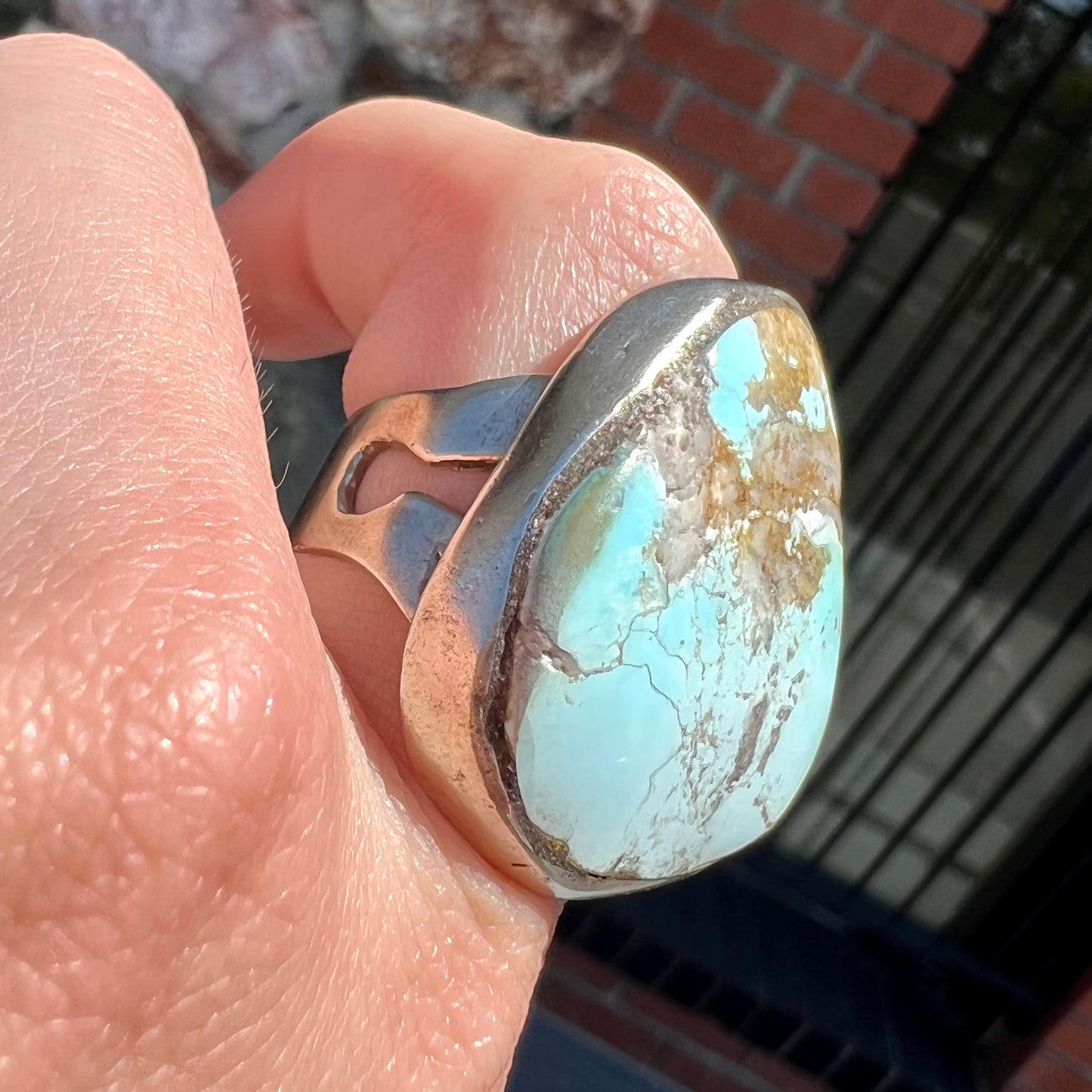 A men's sterling silver ring set with a powder blue turquoise stone. The ring is rustic style.