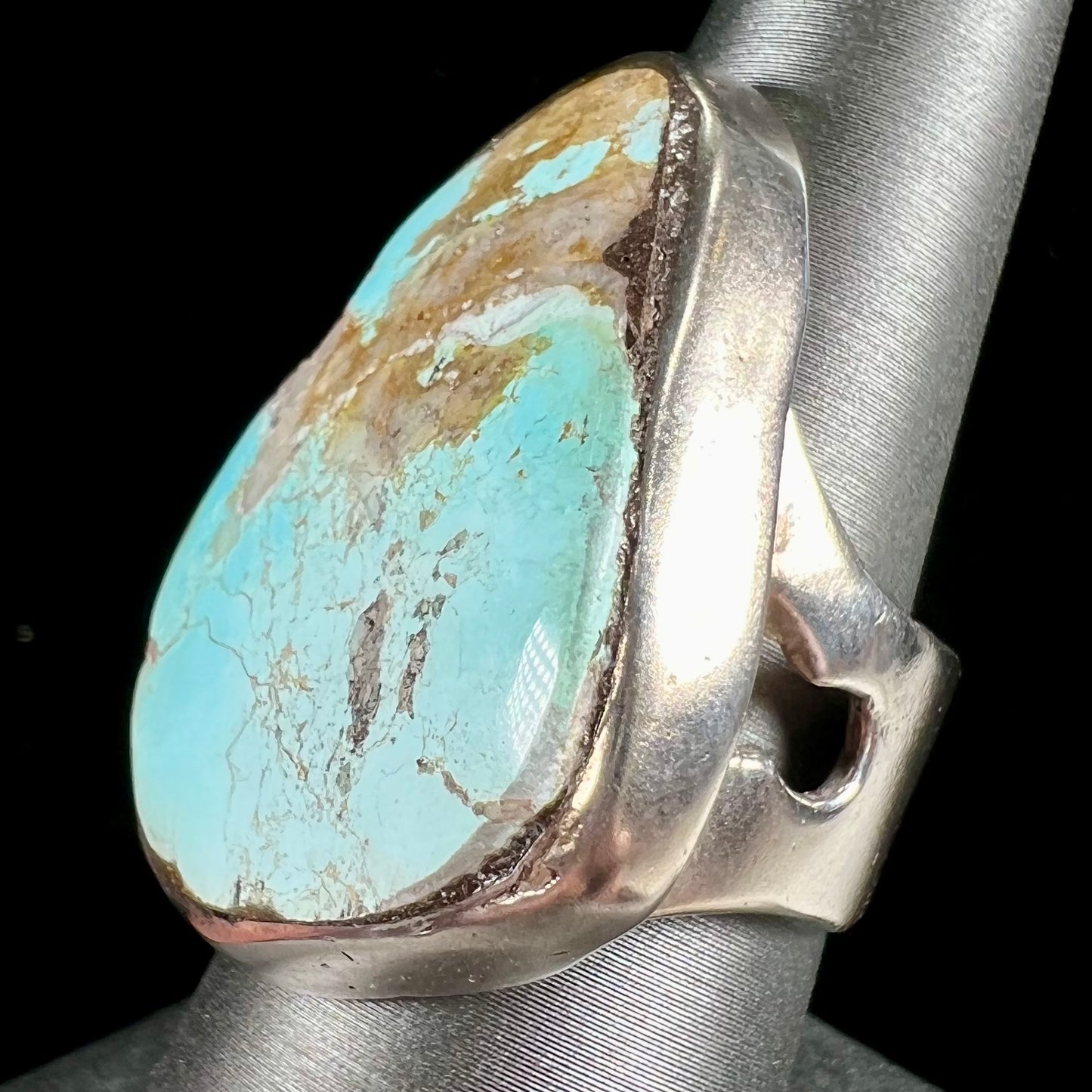 A men's sterling silver ring set with a powder blue turquoise stone. The ring is rustic style.