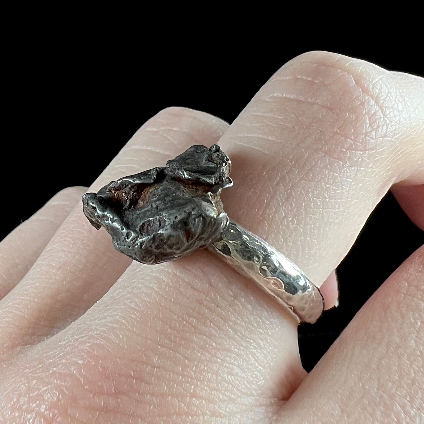 A sterling silver ring set with a Campo del Cielo meteorite.