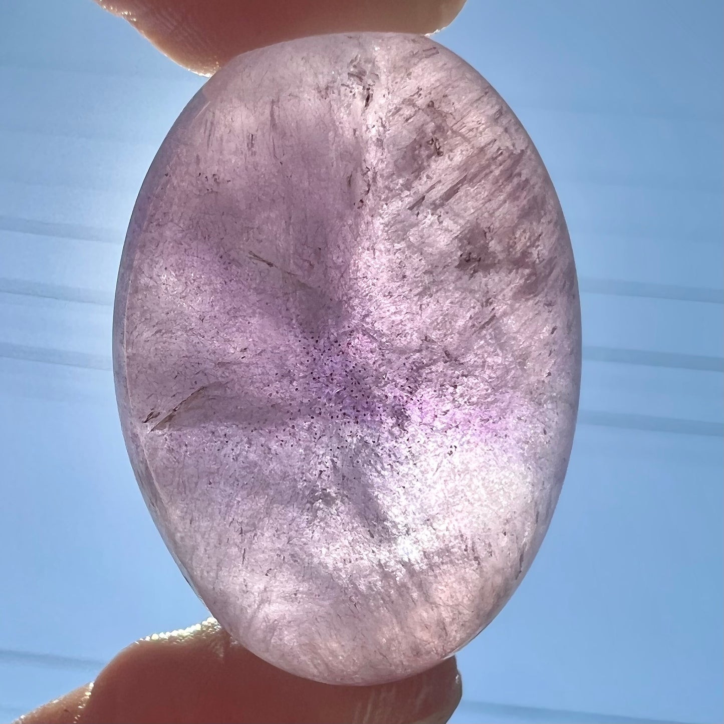 A cabochon cut red amethyst stone from Mexico. The piece shows a faint star.