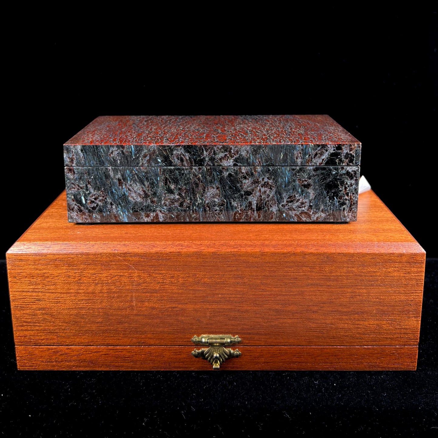 A custom stone box handmade by Gems Art Studio from polished red dinosaur bone and blue pietersite.
