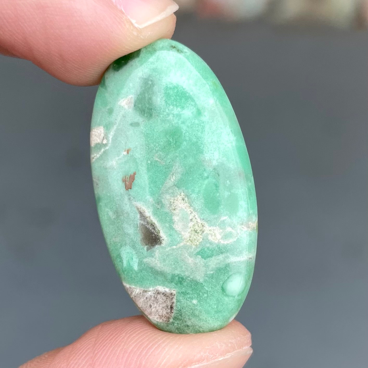 A loose, oval cabochon cut variscite stone from Utah, USA.
