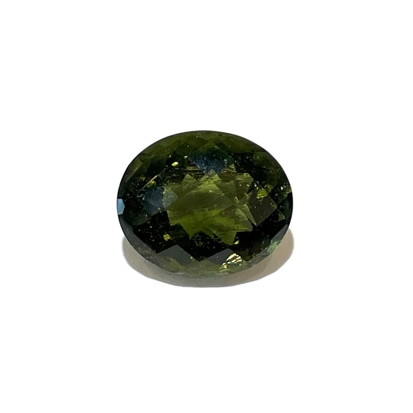 A faceted oval checkerboard cut moldavite gemstone that weighs 4.14 carats.