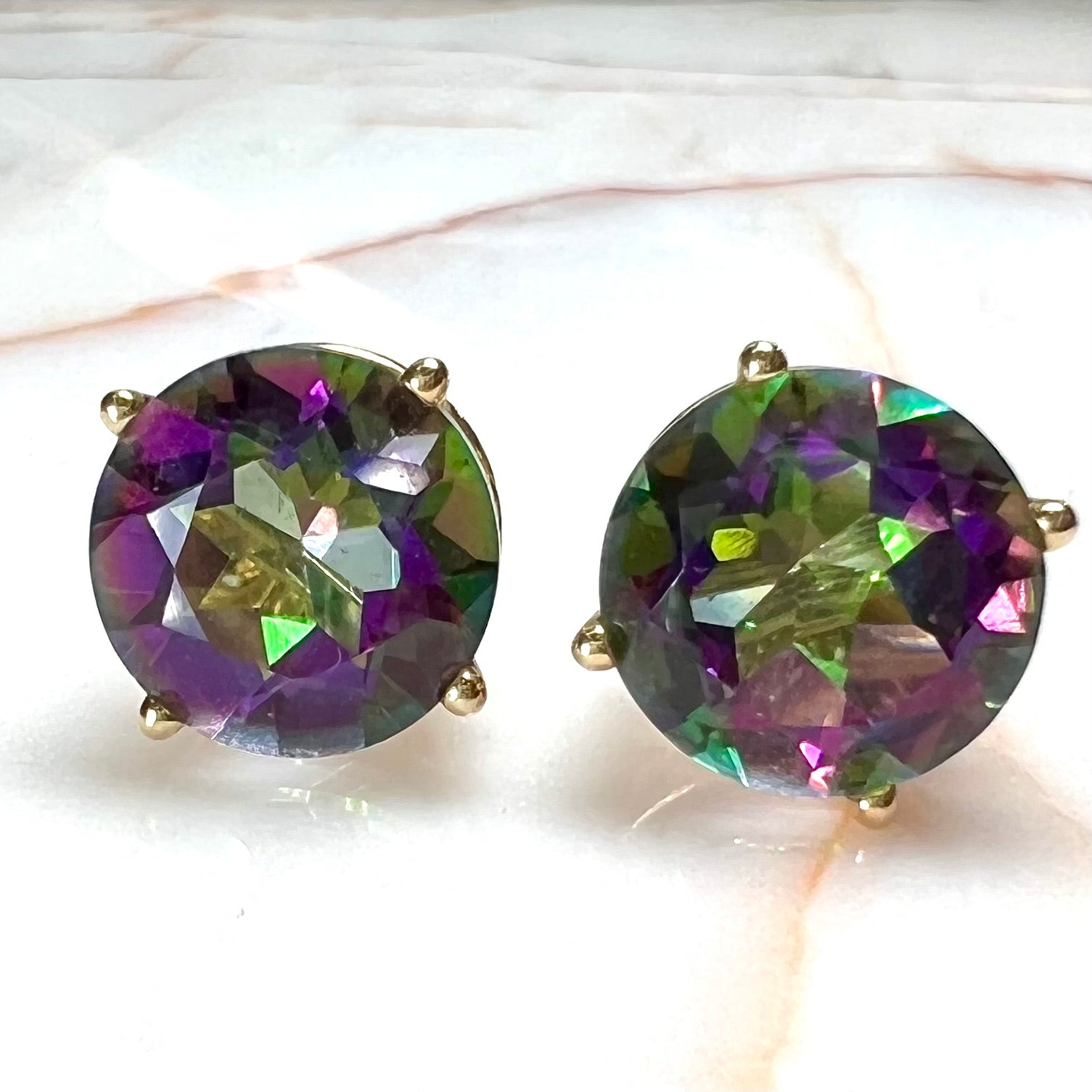 Round cut mystic topaz stones set in yellow gold prong-set push-back earrings.