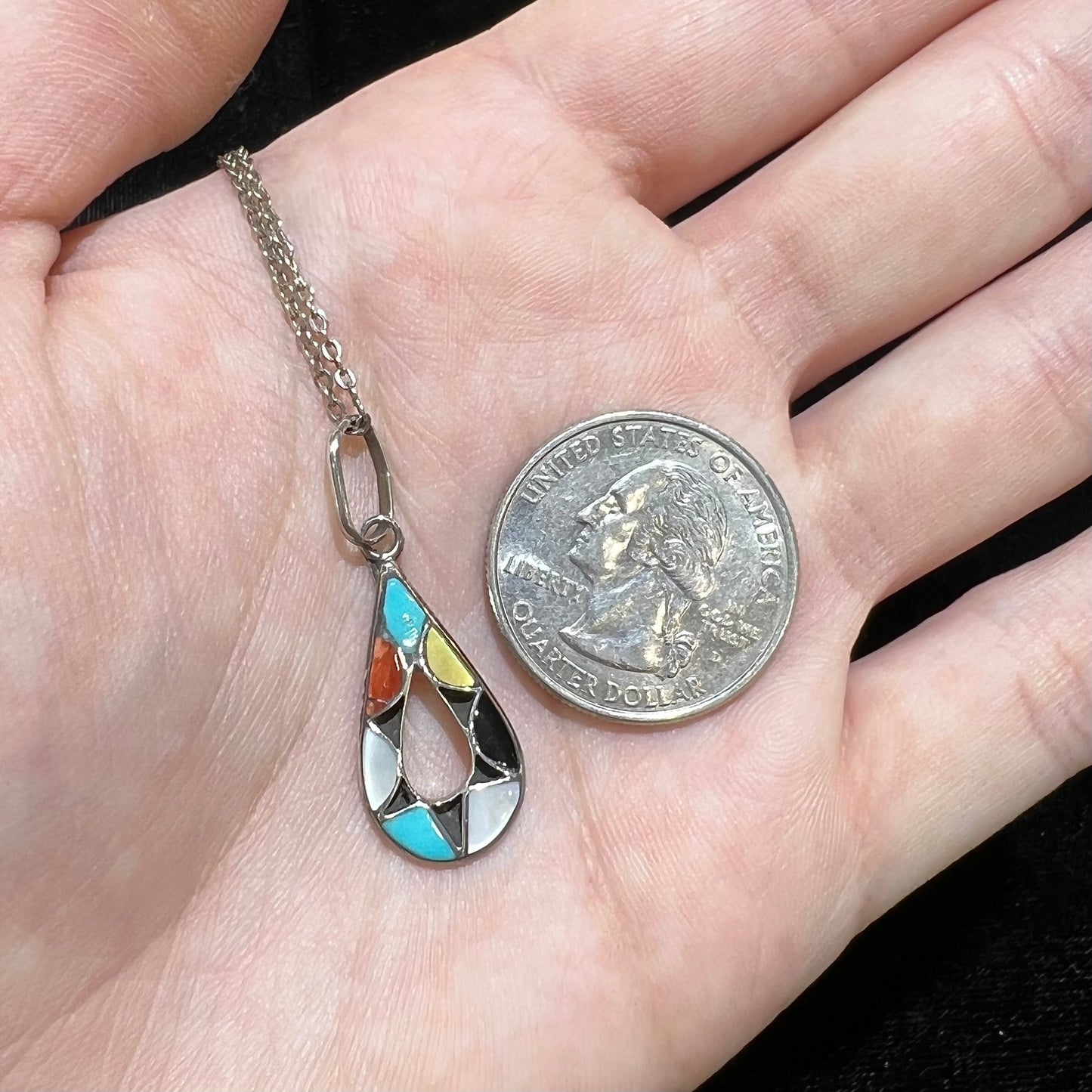 Photo of Zuni Indian pendant with stone inlay of coral, onyx, turquoise, jasper, and mother of pearl.