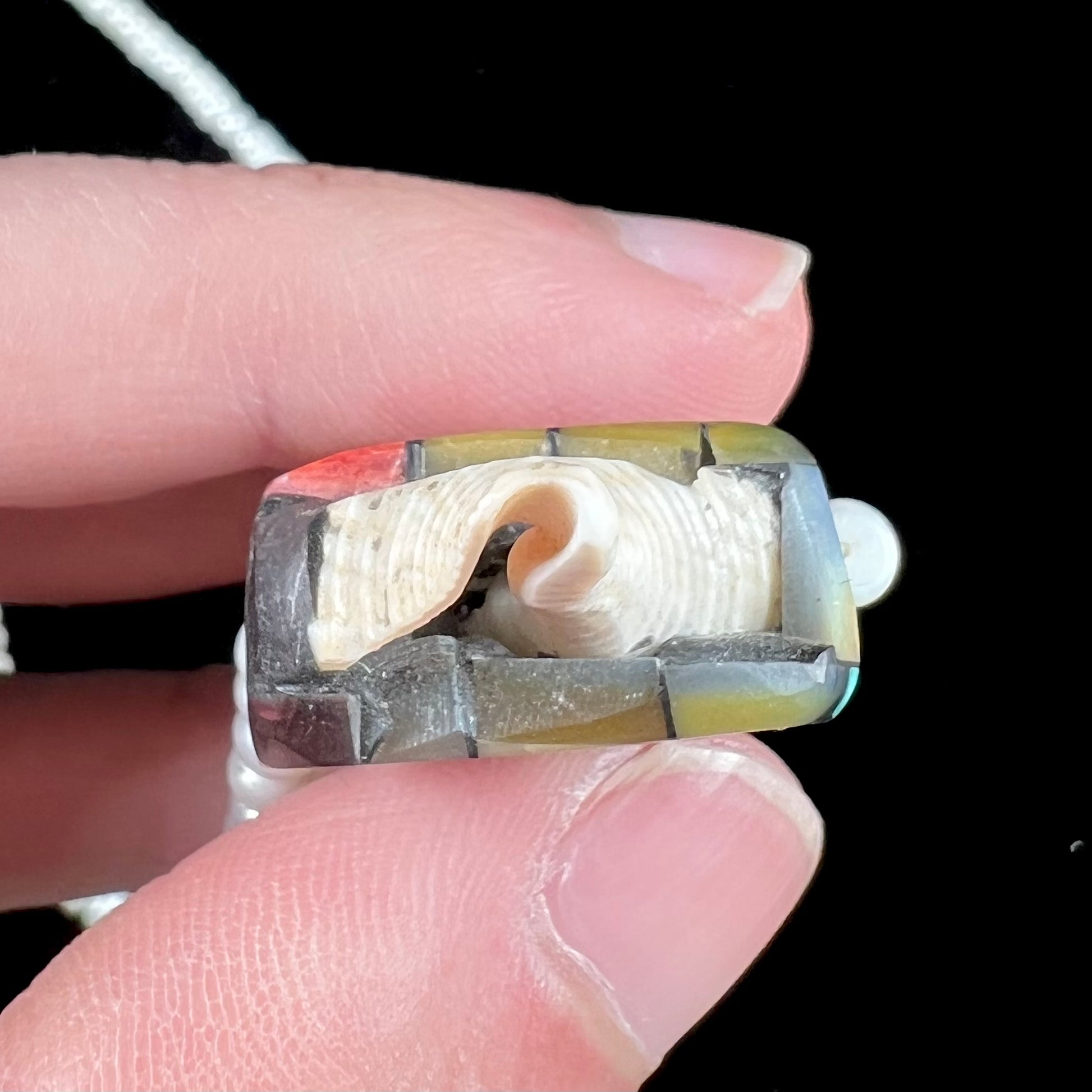 A seashell necklace that has been inlaid with spiny oyster and mother of pearl shell on a pearl bead necklace by Charlene Reano.