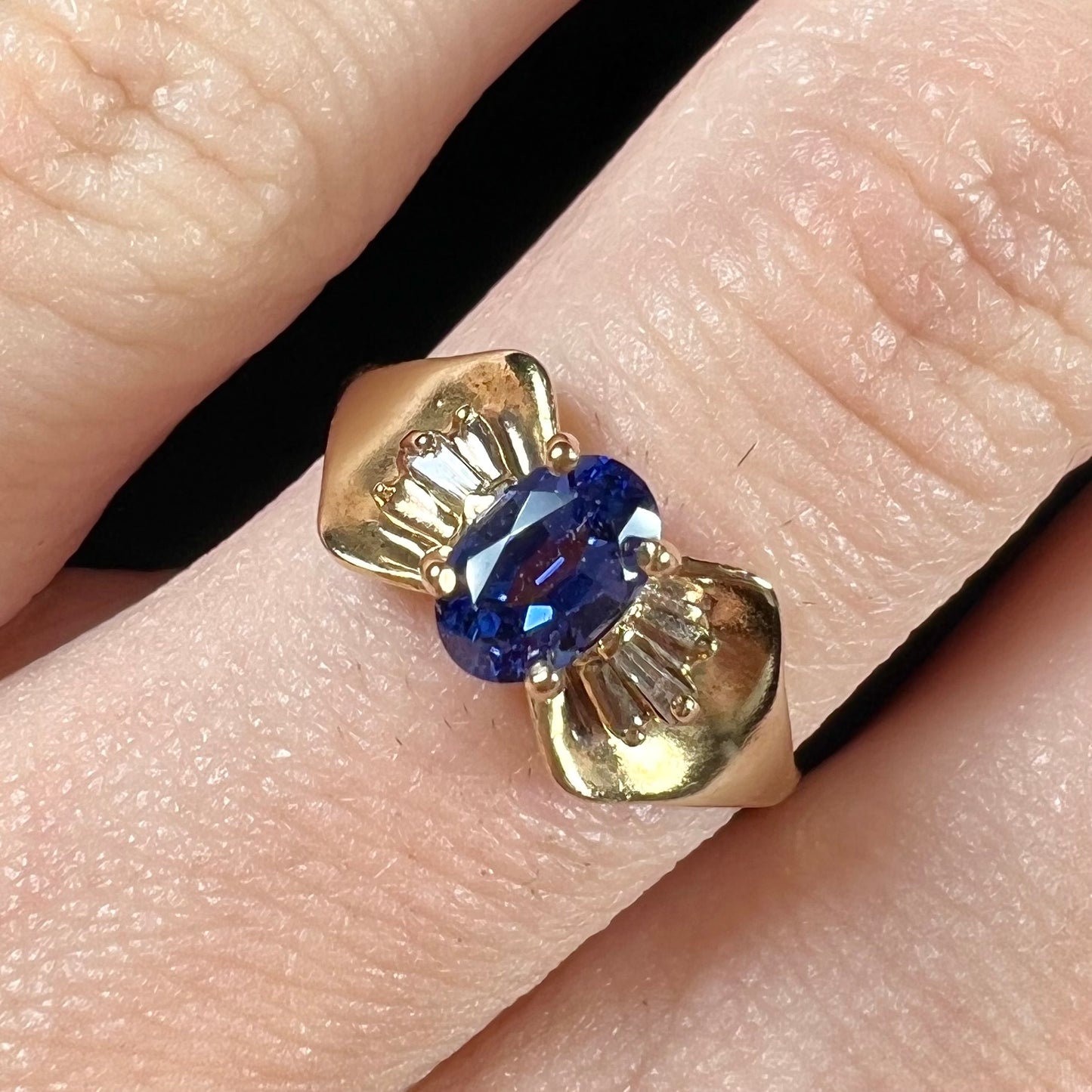 A natural blue sapphire and diamond baguette ring cast in yellow gold.