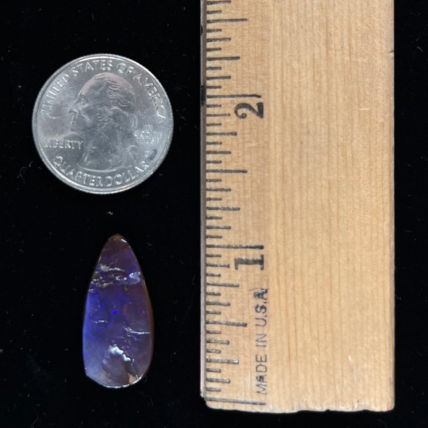 A loose, teardrop shaped purple boulder opal stone.