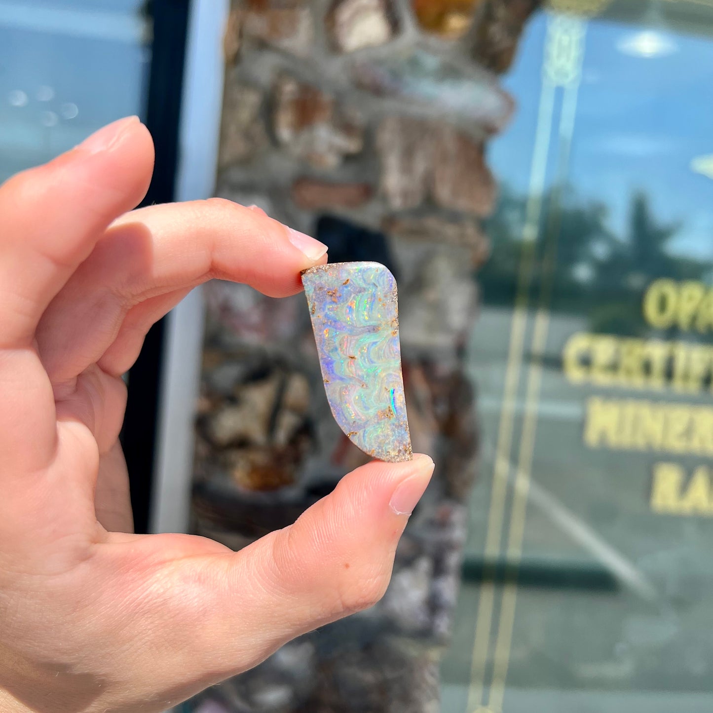 A loose, freeform cut, natural boulder opal stone from Quilpie, Australia.