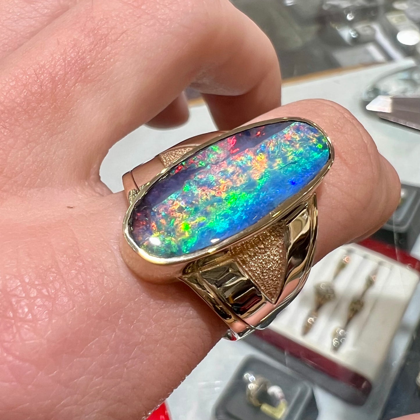 A men's two-tone gold solitaire ring set with a natural boulder opal from Koroit Mining District, Australia.