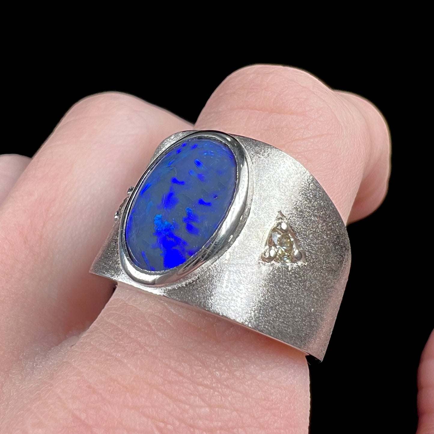 A men's natural black opal and diamond ring cast with a matte finish in white gold.