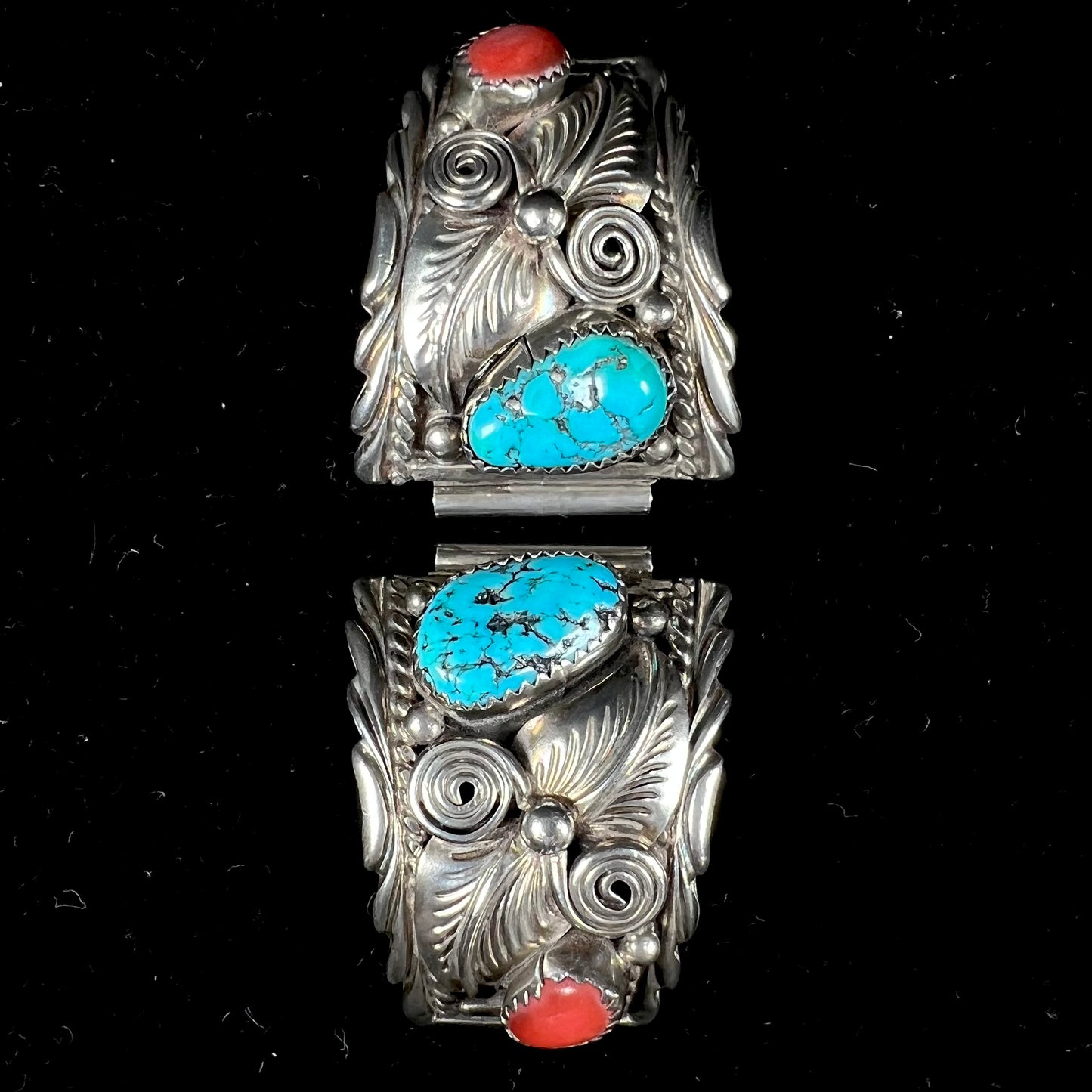 A pair of sterling silver watch cuffs set with turquoise and coral stones.