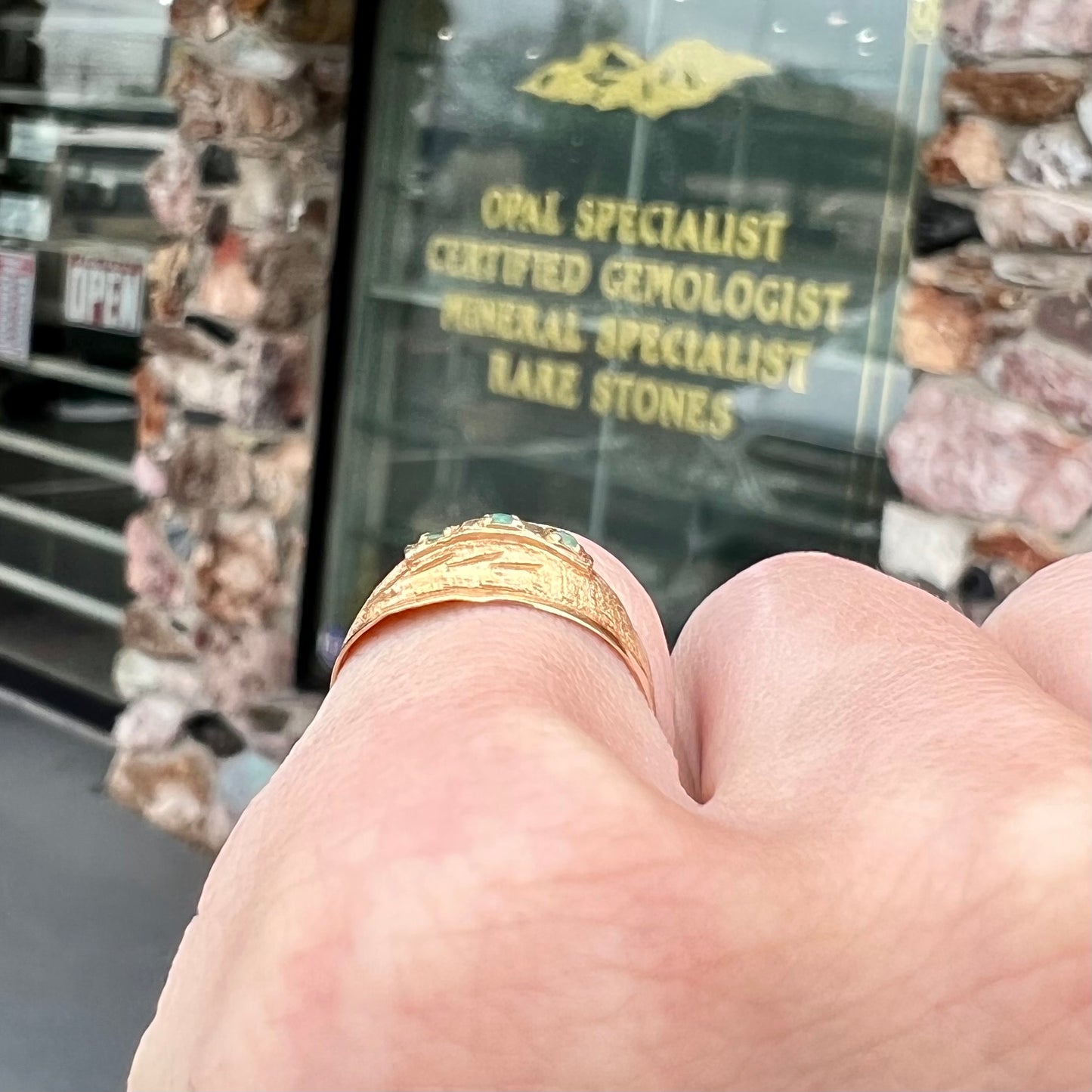 A 1920's style yellow gold three stone round cut emerald ring.