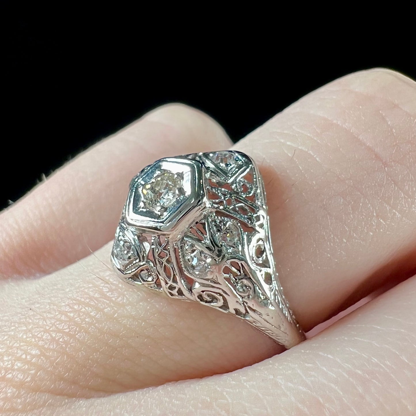 An antique ladies' platinum diamond filigree engagement ring. The center stone is an old European cut diamond.