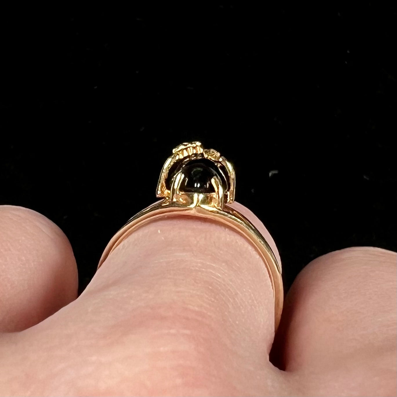 A split shank Black Hills gold ring set with a cabochon marquise cut black onyx.