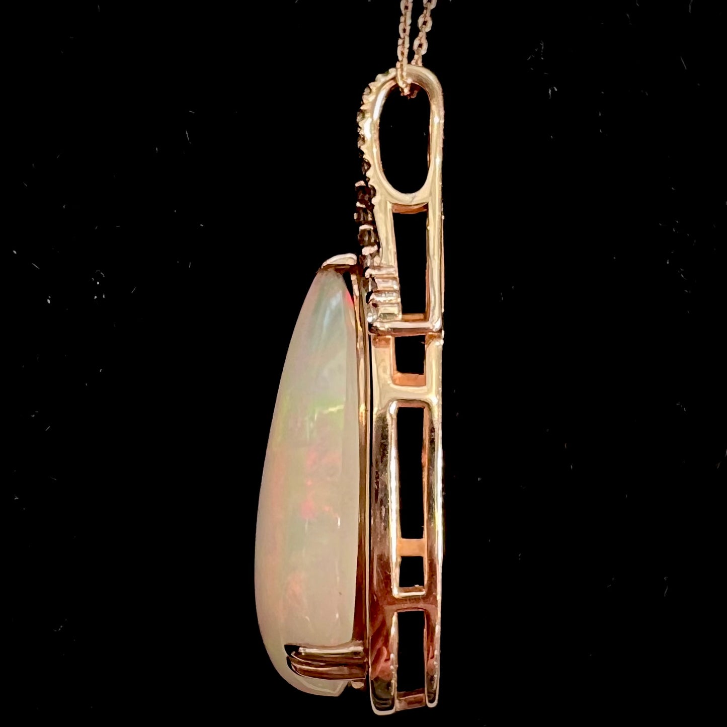 A rose gold, teardrop shaped fire opal and diamond necklace on a cable chain.